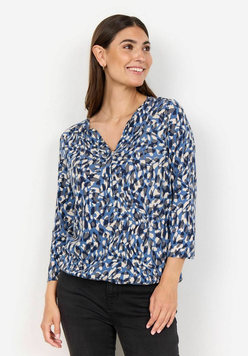 Mönstrad blus i blått, vitt och beige med v-ringning och trekvartslånga ärmar, tillverkad av ett lätt material.