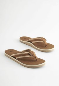 Brūni flip-flopi ar mīkstu, teksturētu virsotni un divām siksnām, ar gaiši bēšu zoli un platu zoles dizainu.