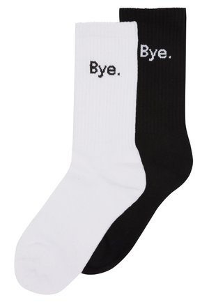 Chaussettes en coton de type crew, une noire et une blanche, avec une texture côtelée et le mot "Bye." brodé en noir sur la chaussette blanche et en blanc sur la chaussette noire.