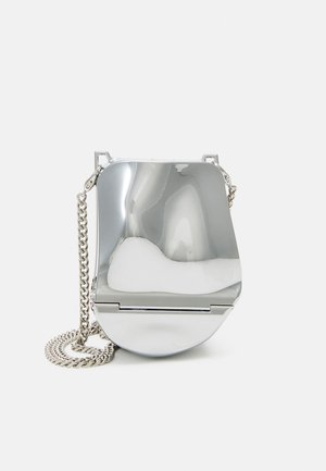 Borsa a mano in metallo argentato con una superficie liscia e curva, dotata di una tracolla a catena e di un chiusura sicura. Forma compatta e finitura riflettente.
