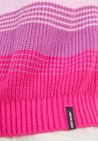 Gebreide trui met horizontale strepen in verschillende tinten roze en paars, met een geribbelde zoom en een klein merkembleem bevestigd.