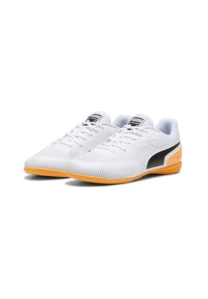 Zapatillas deportivas blancas con parte superior perforada, franja lateral negra y suela de goma naranja. Diseño con cordones y cuello y lengüeta acolchados.