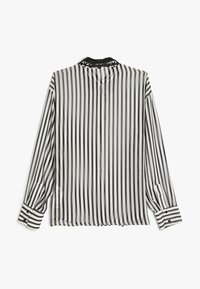 Blusa de manga larga a rayas negras y blancas con tejido transparente, puños abotonados y un detalle de cuello de encaje negro en la parte posterior.
