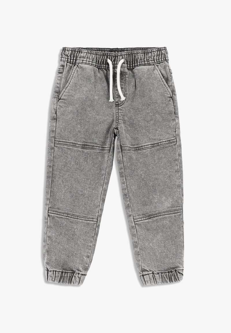 Szare dresy wykonane z miękkiego materiału, z elastycznym pasem w talii i sznureczkami do regulacji, bocznymi kieszeniami oraz elastycznymi mankietami przy kostkach.