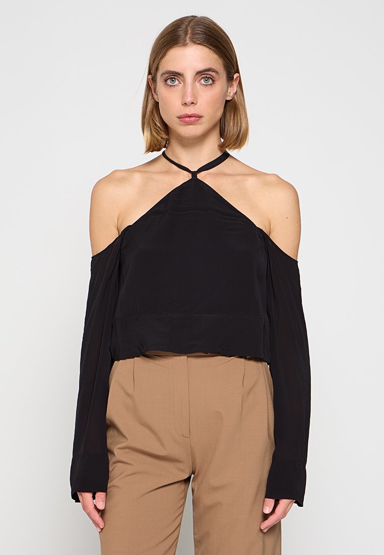 Top nero senza spalle con collo all'americana, maniche lunghe e design corto. Texture liscia e dettagli minimi.