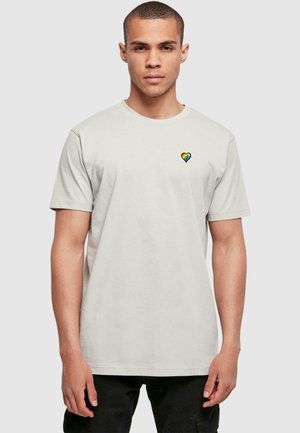 Lichtgrijs katoenen t-shirt met korte mouwen en een ronde halslijn, voorzien van een klein geborduurd regenbooghart op de linker borst.
