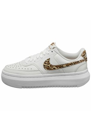 White leather sneakers with a textured white rubber sole, featuring a leopard print Nike swoosh and accents. Round laces and perforated toe design.