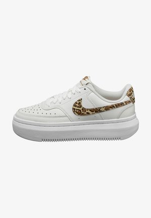 White leather sneakers with a textured white rubber sole, featuring a leopard print Nike swoosh and accents. Round laces and perforated toe design.