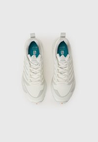 Weiße Sportschuhe mit einer strukturierten Oberseite, grauen Akzenten, Schnürdesign und einer blauen Innensohle. Gummisohle und Zuglasche an der Ferse.