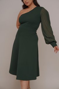 Robe verte avec un design à une épaule, longue manche bouffante, corsage ajusté et jupe fluide, fabriquée dans un tissu lisse avec une finition mate.