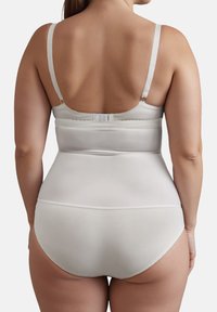 Shapewear bianco con spalline regolabili, una texture liscia e chiusura a gancio e occhiello nella parte posteriore. Progettato per una copertura e un supporto completi.