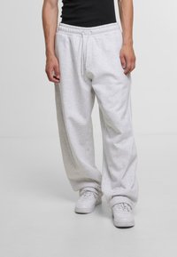 Light gray sweatpants made of soft fabric, featuring an elastic waistband with drawstring, wide leg design, and subtle stitching details.