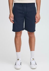 Shorts bleu marine en tissu doux, dotés d'une taille élastique avec cordon de serrage, de poches latérales et d'une coupe décontractée.