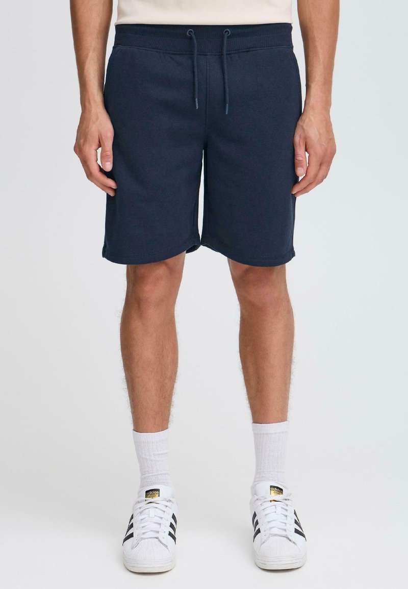 Shorts bleu marine en tissu doux, dotés d'une taille élastique avec cordon de serrage, de poches latérales et d'une coupe décontractée.
