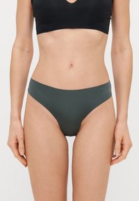 Zöld, sima anyagból készült, varrás nélküli bikini alsó, alacsony derékvonallal. Puha derékpánttal és minimális takarással rendelkezik.