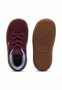 Sneaker in suede bordeaux con suole in gomma naturale, dettagli bianchi e motivi testurizzati. Presenta una suola rotonda e un colletto imbottito per il massimo comfort.