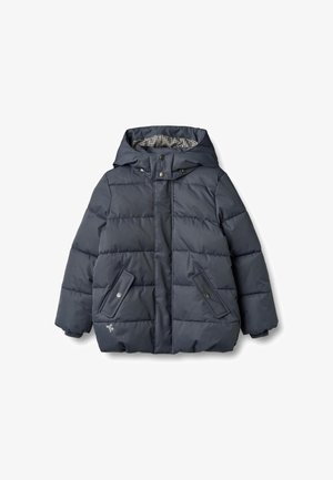 Giacca imbottita blu navy con cappuccio, sezioni trapuntate, tasche con bottoni a pressione e fodera a quadretti. Texture morbida con polsini a coste.