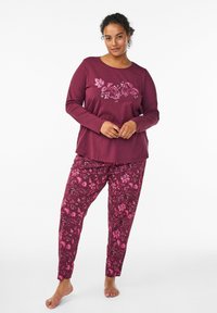 Long-sleeve burgundy top with floral print, paired with matching patterned pants in similar hues. Soft fabric with relaxed fit.