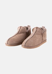 Pantofole in suede marrone con una morbida fodera in pelliccia, caratterizzate da una cucitura bianca a contrasto, punta arrotondata e suola in gomma.