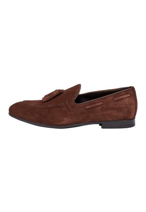 Mocasín de ante marrón para hombre con detalle de borlas, parte superior cosida y tacón bajo negro, mostrado de perfil derecho sobre fondo blanco.