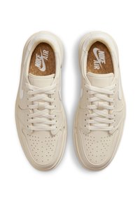Beige Nike Air-sneakers med teksturert skinnoverdel, perforert tåboks, runde lisser og korkinnlegg med logo.