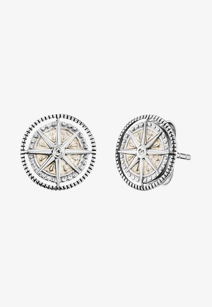 Orecchini a bottone rotondi con un design a bussola in tonalità argento, arricchiti da accenti dorati e piccole pietre trasparenti, dotati di bordi scanalati.