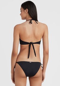 Melns bikini ar halter kakla dizainu, regulējamiem saitēm, bezšuvju apdari un minimālisma stilu. Gluda, elastīga auduma.
