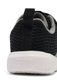 Schwarze Netzsneaker mit strukturiertem Design, ausgestattet mit einer weißen Sohle und einer robusten Schlaufe an der Ferse für einfaches Anziehen.