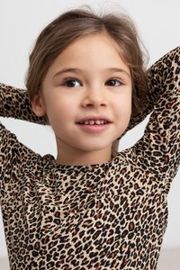 Beige langermet skjorte med svart og oransje leopardmønster. Myk tekstur, tettsittende design og rund hals.