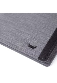 Gray fabric notebook cover with textured surface, black accent edge, and a small embossed logo at the bottom right corner.