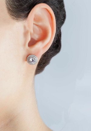 Orecchini a cerchio, montatura in argento con una pietra preziosa trasparente centrale circondata da piccoli accenti scintillanti. Design semplice ed elegante.