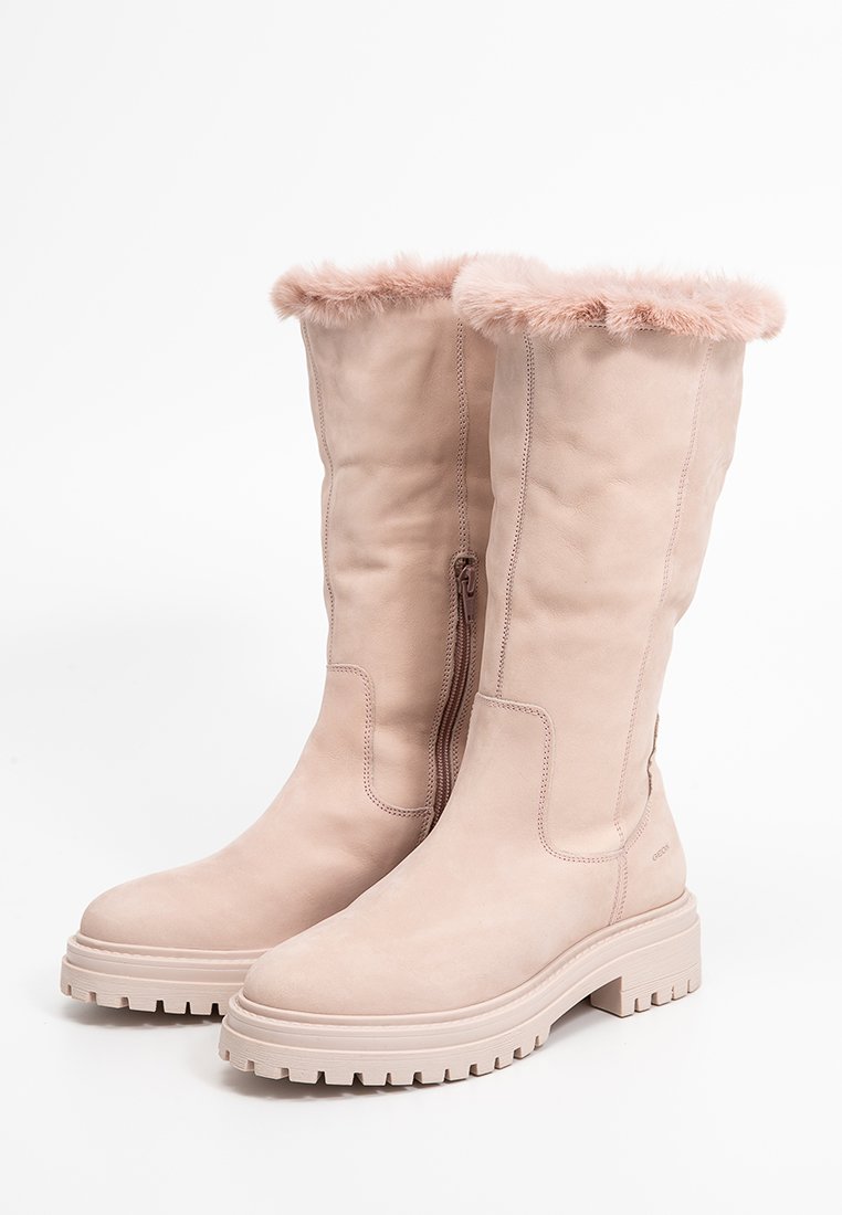 Różowe zamszowe kozaki do kolan z puszystym różowym futerkiem wokół górnej krawędzi, bocznym zamkiem błyskawicznym i masywną, profilowaną podeszwą.