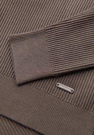 Bruin geribbelde gebreide trui met een gladde textuur en een zilveren "QUINTESSENCE" label. Heeft een band onderaan en details aan de manchetten.