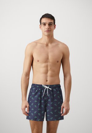 Schwimmshorts in Marineblau mit einem wiederholenden grünen Logo-Muster, elastischem Bund mit weißem Kordelzug, kurzer Länge, aus leichtem Material.