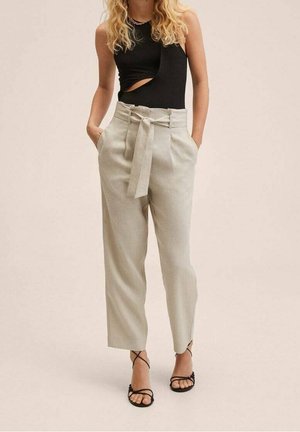 Pantalons gris clair taille haute avec une ceinture à nouer, des plis à l'avant et des poches. Associés à un body sans manches noir et des sandales noires.