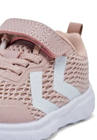 Zapatilla deportiva de malla rosa con una superficie texturizada, diseñada con un acento blanco y una correa de gancho y bucle, que cuenta con una suela acolchada.