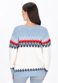 Hellblauer, oversized Pullover mit einem weißen Körper und roten sowie marineblauen gemusterten Akzenten. Weicher Stoff, gerippte Bündchen und runder Ausschnitt.