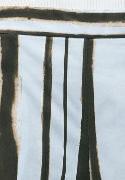 Ανοιχτό μπλε ύφασμα με άνιστες σκούρες καφέ κάθετες ρίγες και οριζόντια ραφή κοντά στην κορυφαία άκρη.