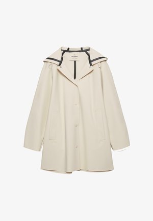 Crème-kleurige, oversized jas van gladde stof. Het heeft een kraag met zwarte accenten, drukknopen aan de voorkant en zijzakken.