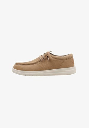 Scarpa in pelle beige con punta arrotondata, superficie texturizzata e design con lacci. Presenta una suola in gomma bianca e dettagli cuciti discreti.