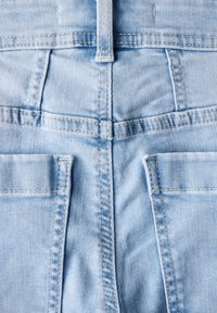 Jeans di denim azzurro chiaro con una texture liscia, caratterizzati da due tasche posteriori e una cucitura centrale. La cintura presenta un dettaglio di cucitura rinforzata.