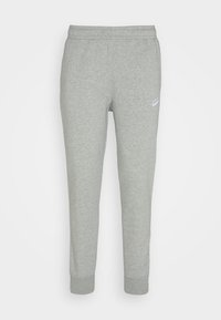 Pantalon de survêtement gris en matériau doux, avec un design fuselé, une taille élastique et un petit logo Nike blanc sur la hanche gauche.
