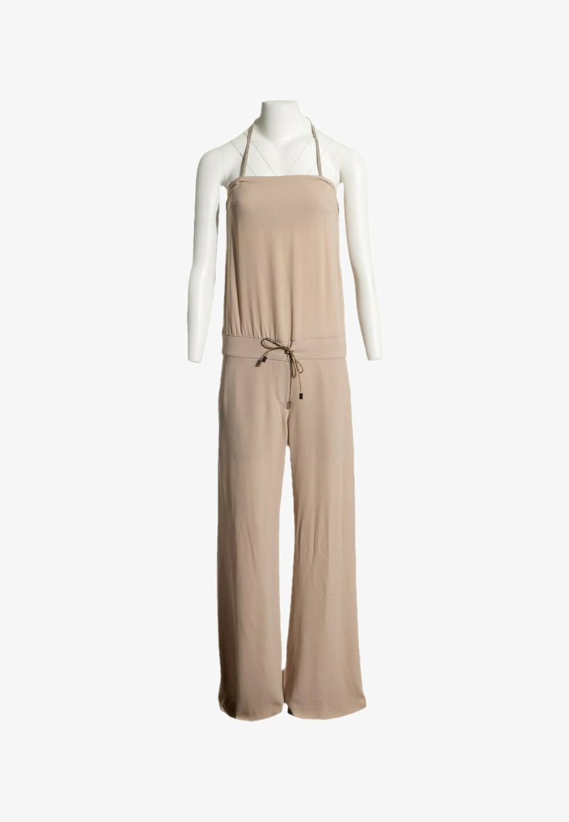 Combinaison beige sans manches avec bretelles halter et taille à cordon sur un mannequin blanc.