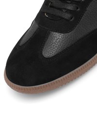 Mustade tossud, millel on nubukist ja tekstuuriga nahast paneelid, paelad ning pruun kummitald.