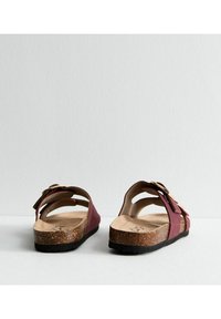 Burgundy sandaler med korkfotbädd, öppen bakdel och justerbart spänne. Har en slät yta och ett stödjande fotbädddesign.