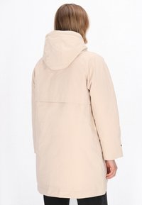 Lys beige, vandtæt jakke med hætte, afslappet pasform, mid-length design og synlige syninger på ryggen og ærmerne.