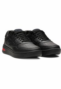 Black synthetic leather sneakers with perforated detailing, flat laces, and a red accent on the heel. Thick rubber sole for support.