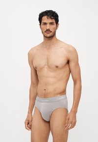 Sivi bombaženi kratki hlački z svetlo sivim pasom, ki nosi logotip "Calvin Klein". Gladka tekstura, tesno prileganje, klasičen dizajn.