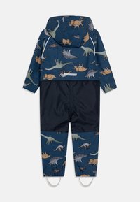 Fato de chuva com padrão de dinossauros em tons de azul e terra, apresentando um capuz, punhos elásticos e uma parte inferior em azul escuro.