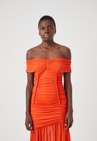 Πορτοκαλί φόρεμα που αφήνει τους ώμους ακάλυπτους με πτυχώσεις, εφαρμοστό κορσέ και ρέουσα κάτω μέρος. Λείο ύφασμα με φρουφρού λεπτομέρειες σε όλη την επιφάνεια.
